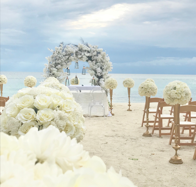 White flowers, sand, blue sky. Destination wedding